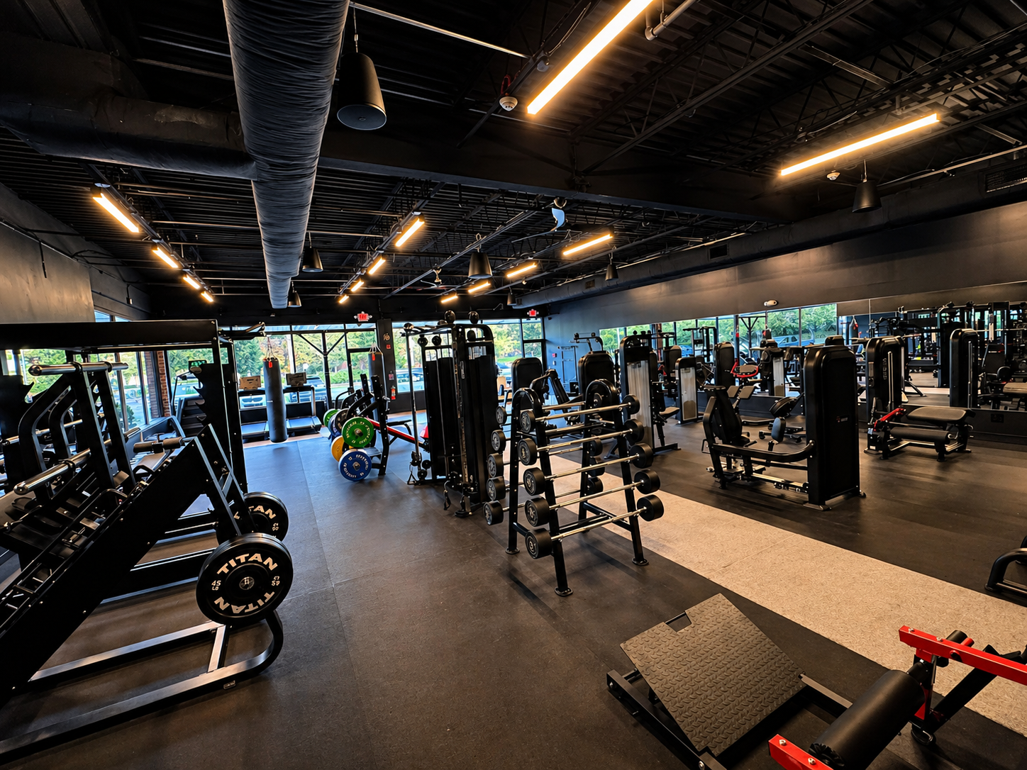 Wide view of the GabaiFitness training floor with racks, plates and machines